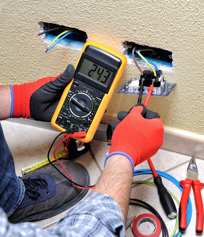 Electrician working on wall outlet